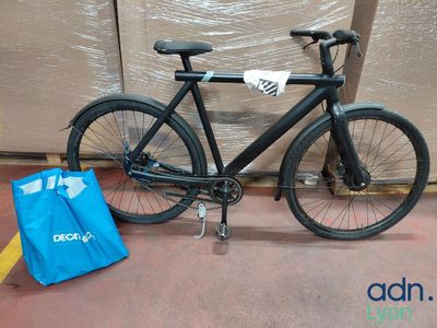 un vélo noir garé à côté d'un sac bleu