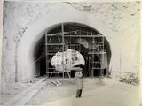 une vieille photo en noir et blanc d'un homme debout devant un tunnel