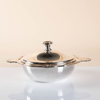 a silver pot with a lid sitting on a table