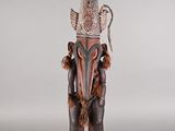 statue d'un homme avec un oiseau sur la tête et une plume sur la tête