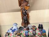 une statue représentant un homme tenant une guitare, posée sur une table aux côtés d'autres figurines