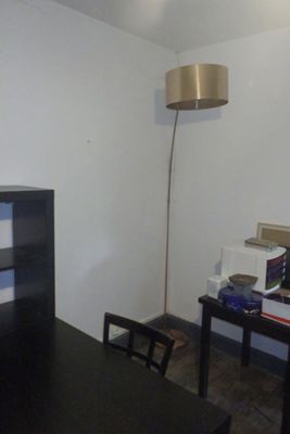 un bureau avec une lampe et une bibliothèque dans un coin
