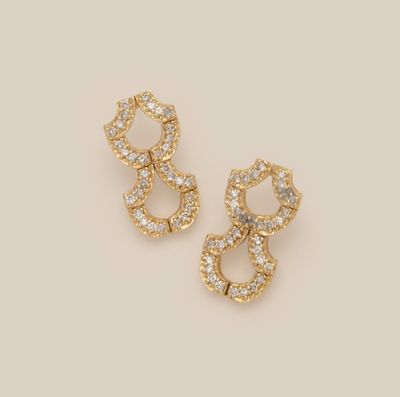 a pair of gold and diamond earrings on a white background