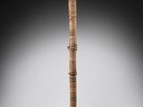 a tall wooden stick with two hands on top of it