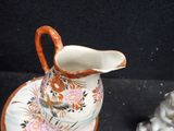 a small vase and saucer sitting on a black surface
