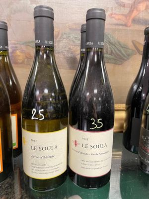 several bottles of wine are lined up on a counter