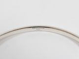 a close up of a silver bracelet with a diamond on it