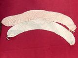 three pieces of white crochet on a red cloth