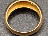 an image of a gold ring with a red stone in the center