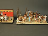 two figurines of people and a building on a table