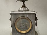 a silver clock that is sitting on top of a table
