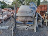une bétonnière qui est posée sur le gravier