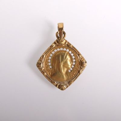 an image of a gold pendant with a woman ' s face in the center
