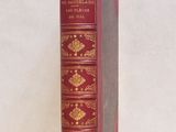 un livre rouge avec des inscriptions dorées sur une couverture blanche