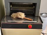 un plumeau et une brosse posés sur une machine