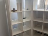 a corner of a room with a desk and a bookcase