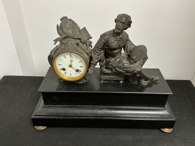 une statue représentant un homme assis sur un banc à côté d'une horloge