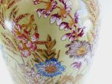 a vase with a floral design on it sitting on a table