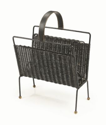 a black wicker magazine rack with a magazine holder on it