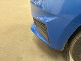a close up of a blue car parked in a parking lot