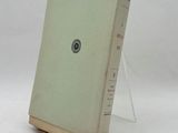 an old book sitting on top of a table on a white surface