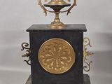 a black and gold clock with a gold plate on top of it