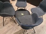 three chairs and a table in a room with wood flooring