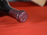 a bottle of wine sitting on a red table cloth