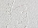 someone is drawing a face on a piece of paper with a pencil
