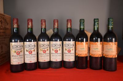 six bottles of wine are lined up on a red table