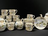 de nombreuses tasses, soucoupes et théières sur la table