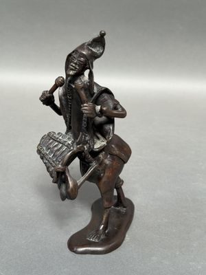 bronze figurine of a man with a bird on his shoulder