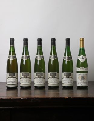 six bouteilles de vin sont alignées sur une table en bois