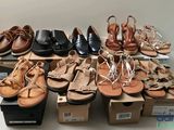 many pairs of women ' s sandals on display in a box