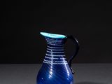 a blue vase sitting on a table with a black background