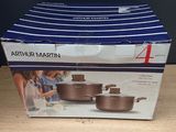 emballage d'un lot de quatre casseroles et poêles posé sur une table