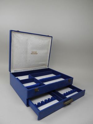 an open blue box with two drawers and a pair of scissors