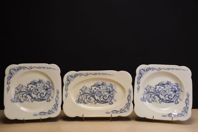 Trois plats en faïence à décor d'arabesques bleues.