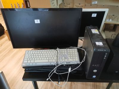 a desk with a computer, keyboard, and monitor on it