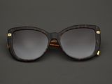 un gros plan sur une paire de lunettes de soleil posée sur une surface noire