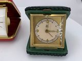 a small clock sitting next to an open box