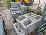 a pile of cinder blocks sitting next to a fence