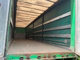 un grand camion vert avec une benne à l'arrière