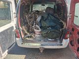a red van with a bunch of branches in the back of it