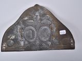 a metal object with a crown on it on a white surface