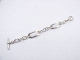 a close up of a silver chain bracelet on a white surface