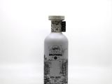 the bottle is full of a white liquid with a black and white drawing on it