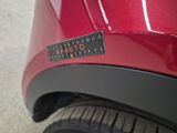 a close up of a red car with a sticker on it