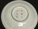 a white plate with red writing on it on a black table