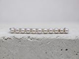 a close up of a white pearl ring on a concrete surface